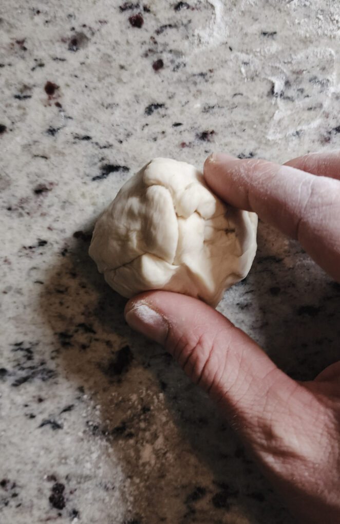 Pinching the seams of naan dough ball