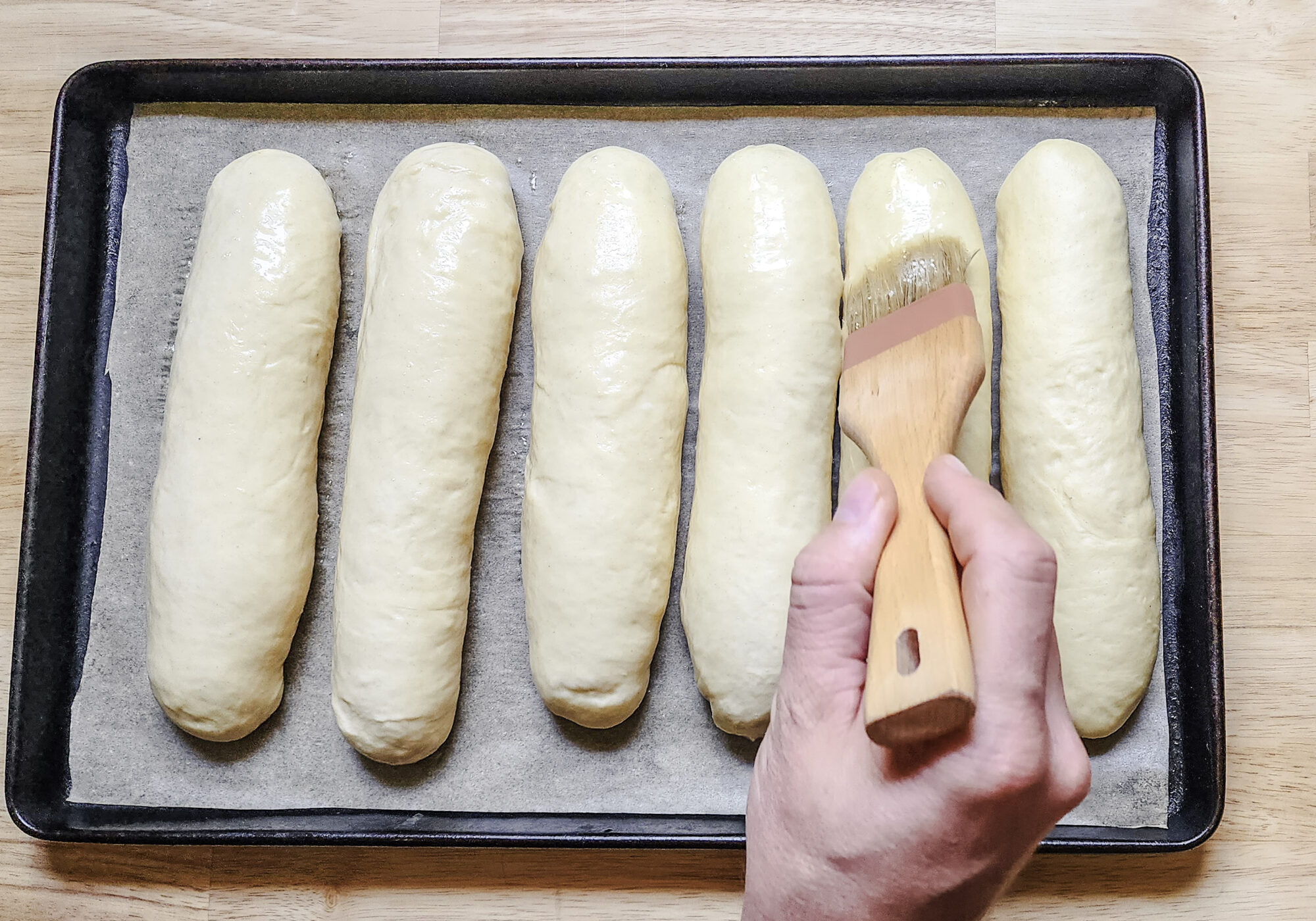 Brushing sub roll loaves with egg wash