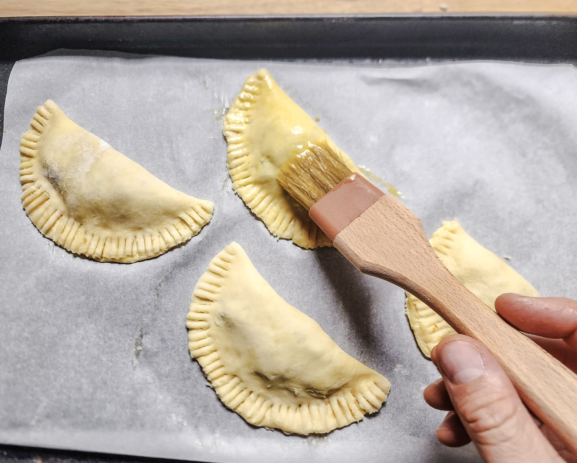 Applying egg wash on apple pies