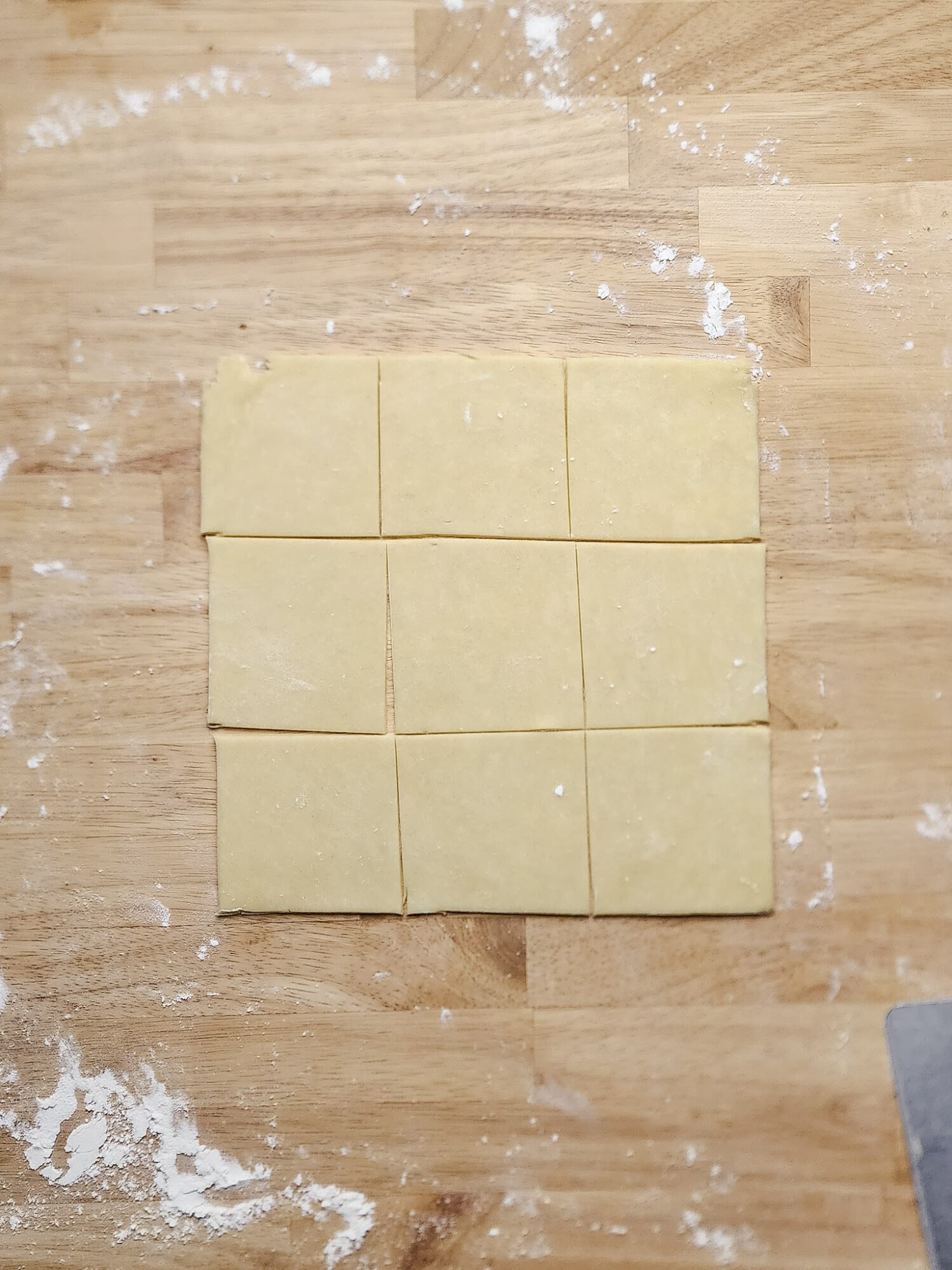 Kolaczki dough divided into evenly into 3-inch squares