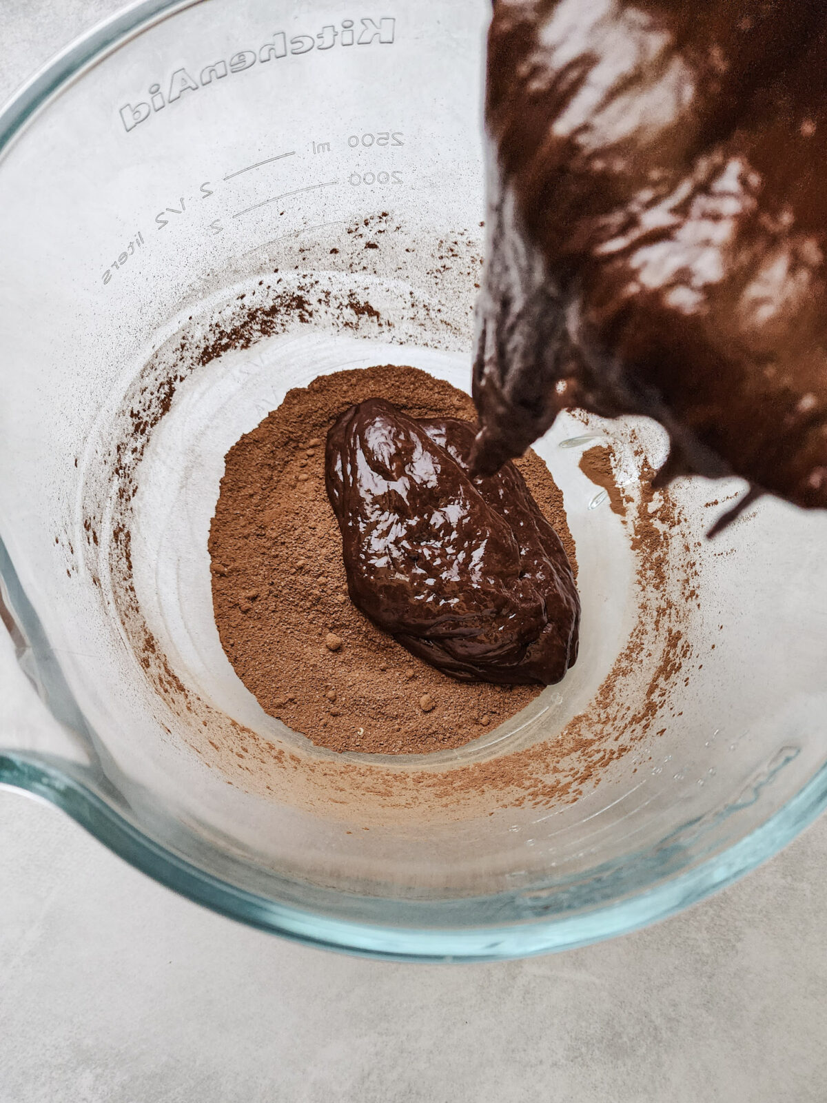 Adding the wet ingredients to the dry for flourless German chocolate cake.