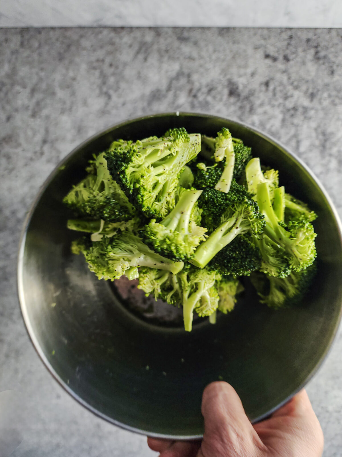 Tossing broccoli in oil and salt and pepper for Korean Beef and Broccoli Bowls