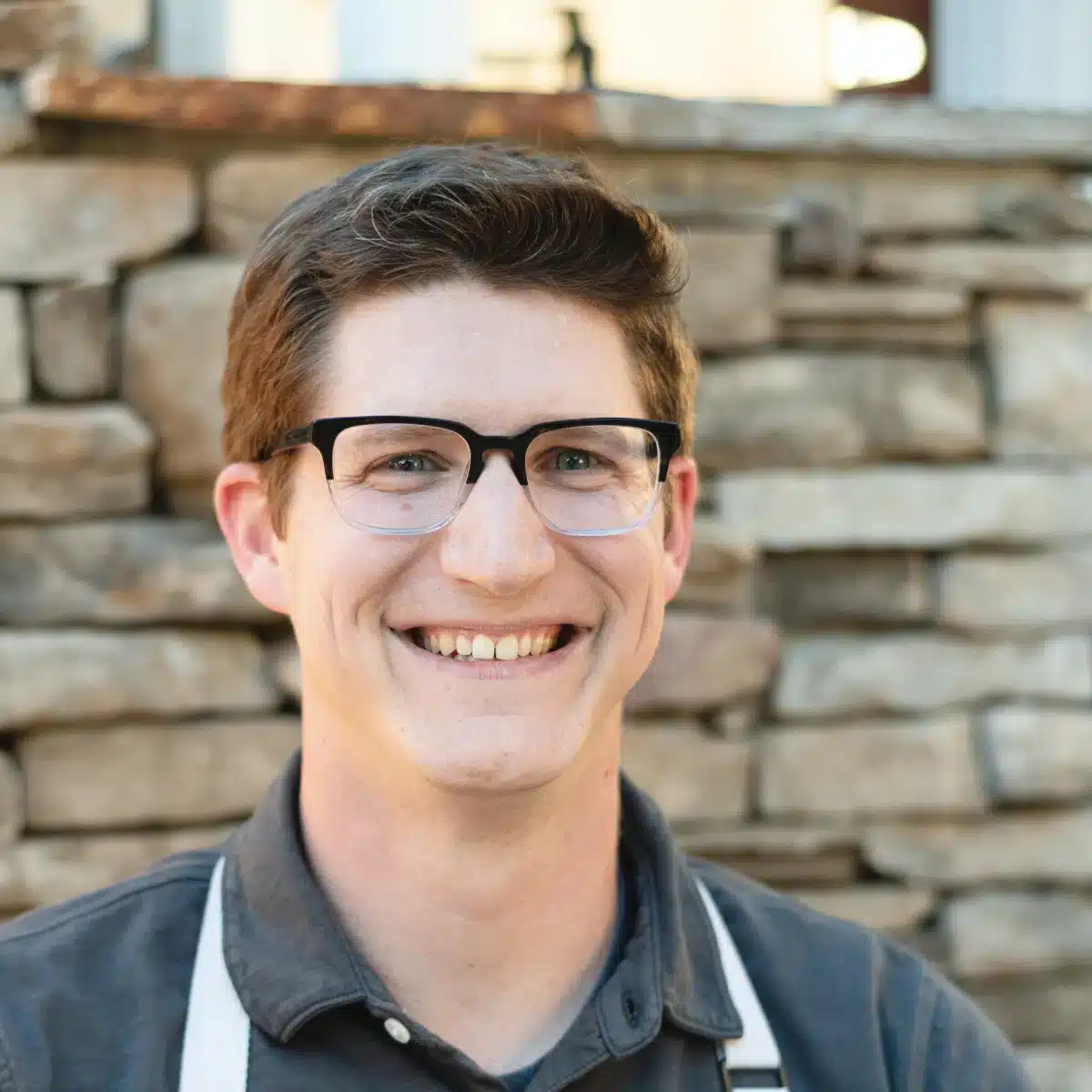 A picture of Spencer Klickman, author and recipe developer for the Kitchen Coalition in front of a stone wall.