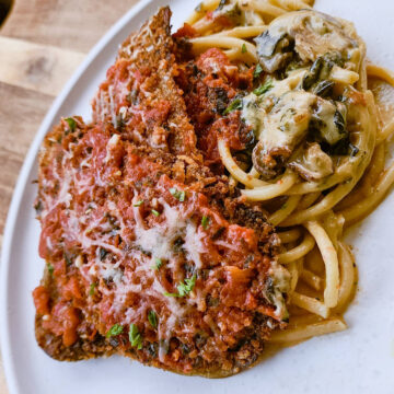 Sunday Eggplant Parmesan served over a bed of creamy pasta.