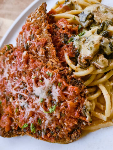 Sunday Eggplant Parmesan served over a bed of creamy pasta.