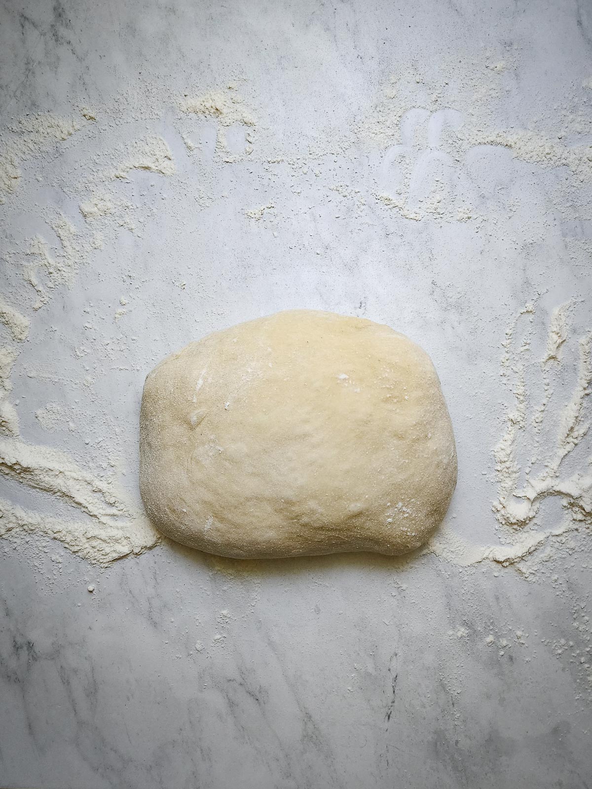 Chai-Spiced Cinnamon Roll - Assembly Step 1: Begin by punching the dough down, and turning it out onto a lightly floured work surface.