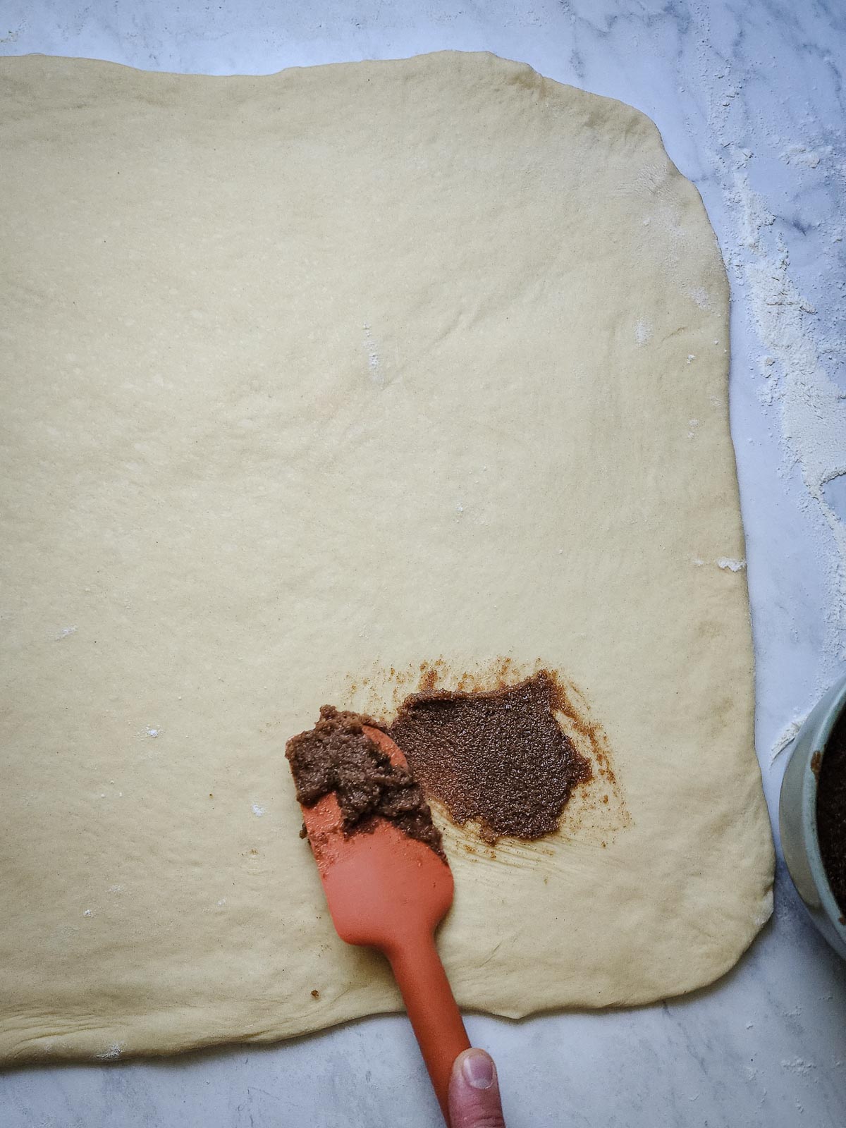 Chai-Spiced Cinnamon Roll - Assembly Step 3: Spread the softened chai-spiced filling all over the dough.