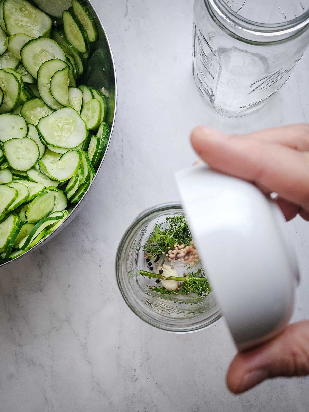 Easy Refrigerator Dill Pickle Slices Step 3: Prepare the mason jars by placing half of the fresh dill, garlic, mustard seeds, black peppercorns, coriander seeds and red pepper flakes into the bottom of each jar.