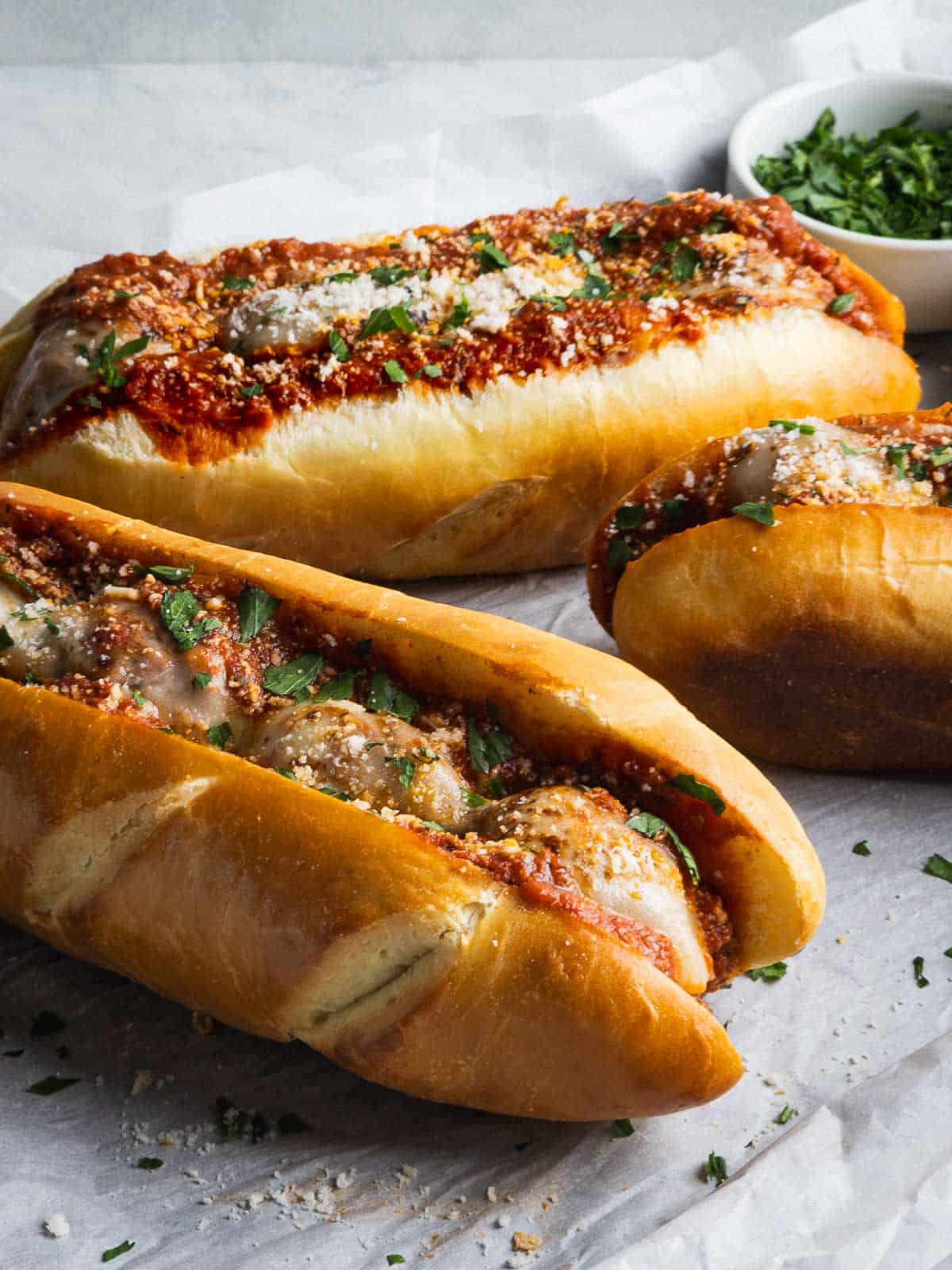 Baked meatball sub sandwiches with melty cheese and parsley on homemade sub rolls.