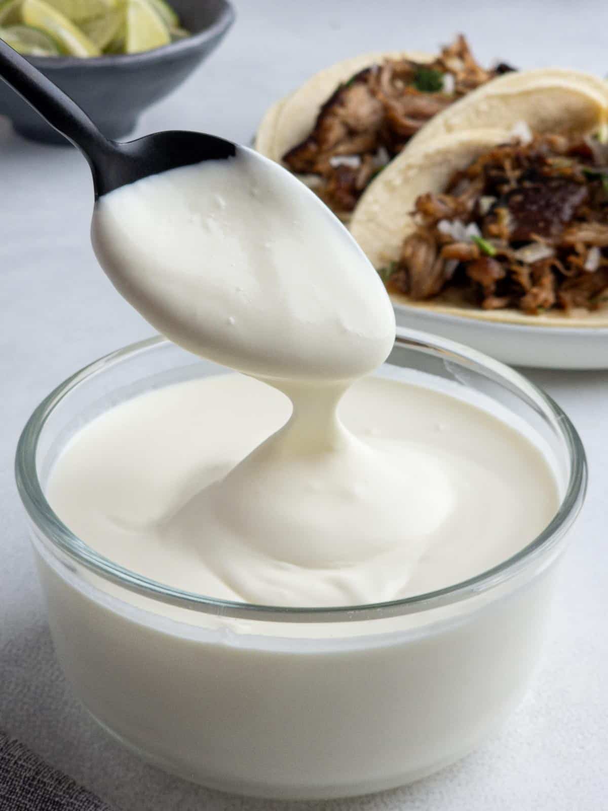 Mexican crema drizzling off a spoon.