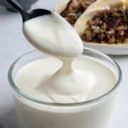 Mexican crema drizzling off a spoon.