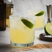 Two glasses with salted rims with Reposado Margaritas made with fresh lime juice.