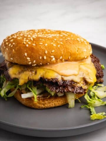 Classic double smash burger with crispy edges, melty cheese, and homemade burger sauce on a plate.